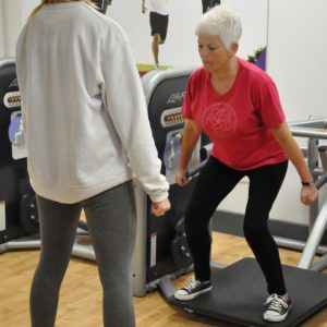 Woman exercising in gym with personal trainer