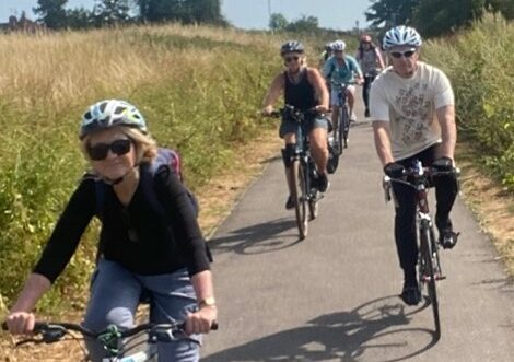 Group of people cycling along path