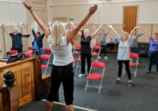 Instructor leading an exercise class for older people