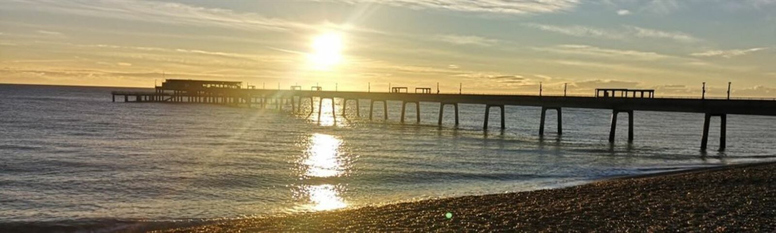 deal pier with sunset behind