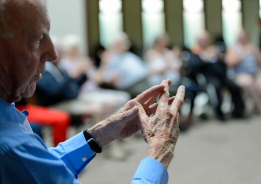 man holding his hands out in an exercise class