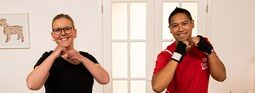 Two people shadow boxing in their home