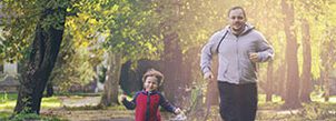 man and boy running in the park