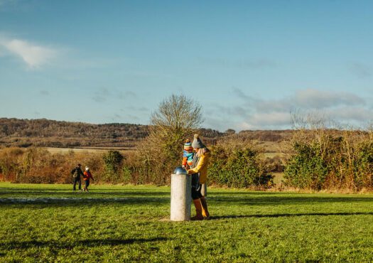 person with child in a field on a walk