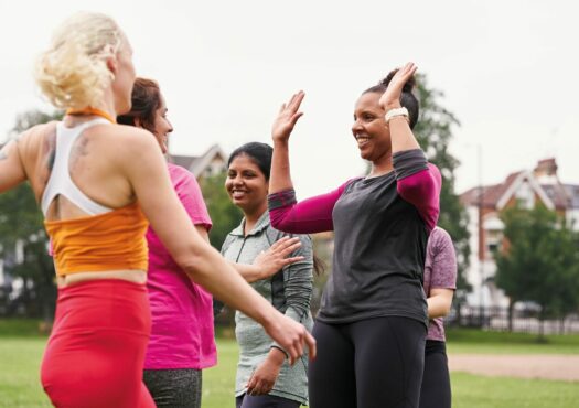 ladies in park high fiving after exercise