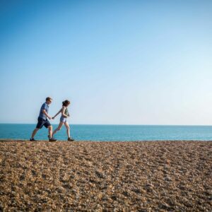 two people walking on beach